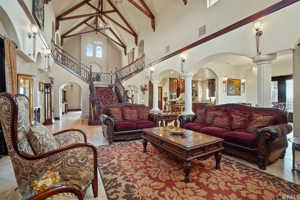 39150 Vía De Oro Temecula, CA 92592 - Photo 29 of 60 a living room with furniture a fireplace and a chandelier