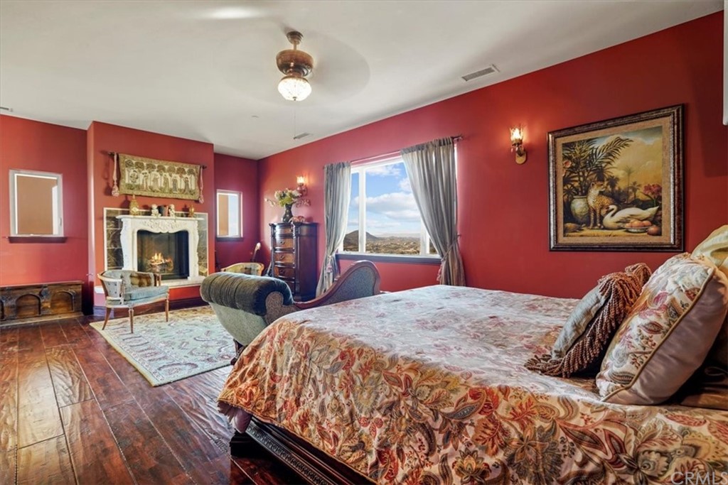 39150 Vía De Oro Temecula, CA 92592 - Photo 31 of 60 a bedroom with a large bed and a fireplace