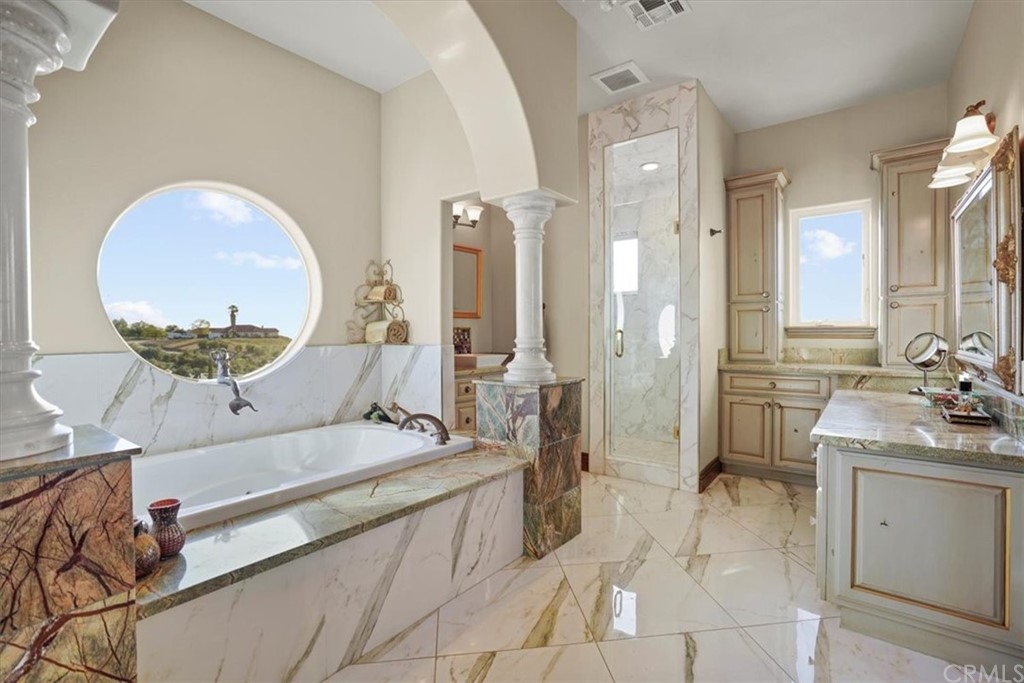 39150 Vía De Oro Temecula, CA 92592 - Photo 35 of 60 a spacious bathroom with a double vanity sink a mirror and a bathtub