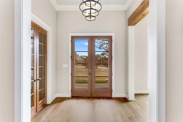 a view of an empty room with wooden floor fireplace and a window