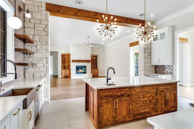 a large white kitchen with a chandelier