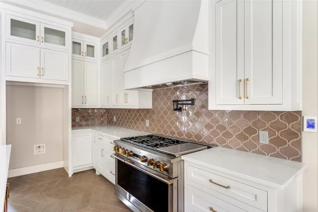 a kitchen with stainless steel appliances white cabinets and a window