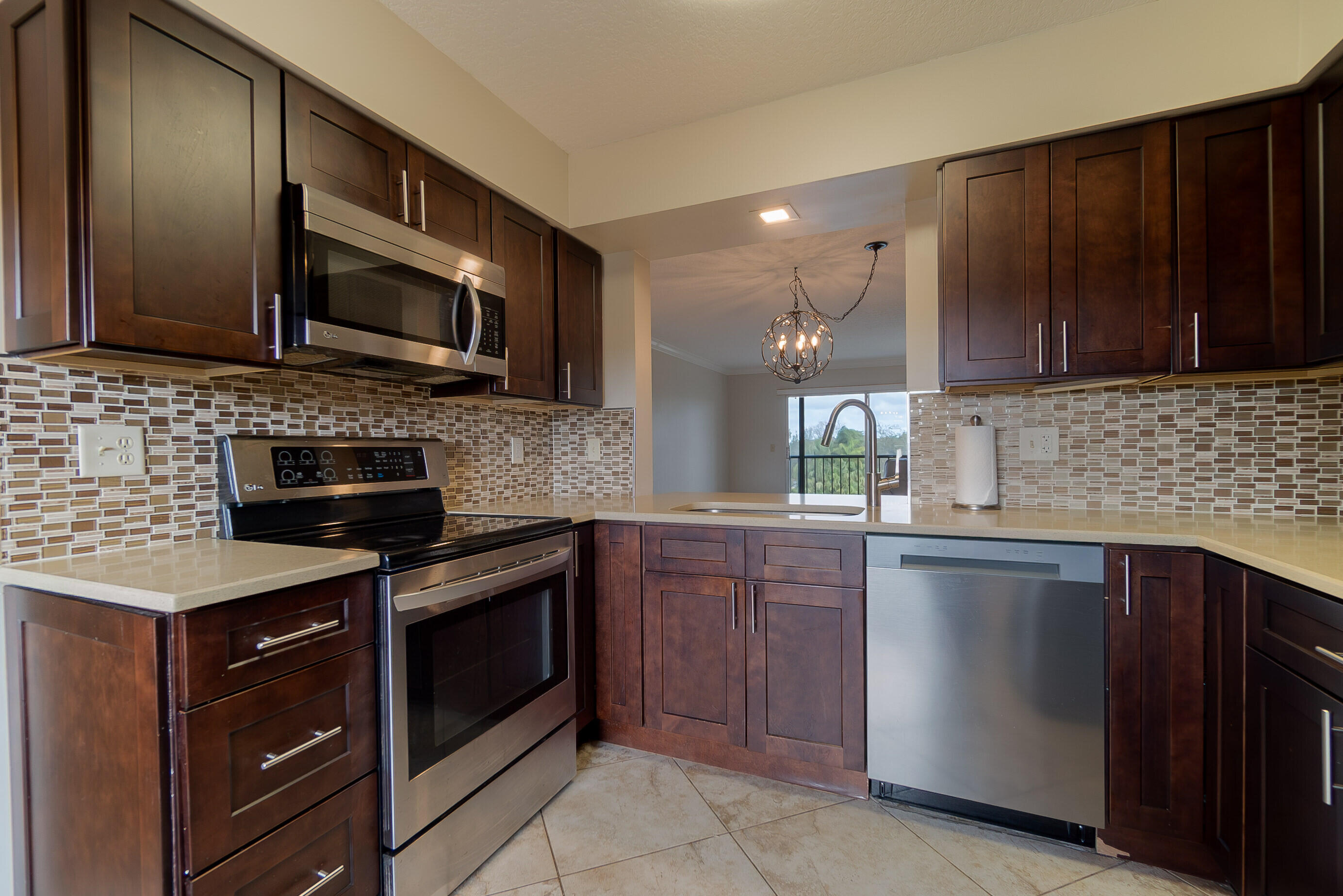 a kitchen with stainless steel appliances granite countertop wooden cabinets and a stove top oven