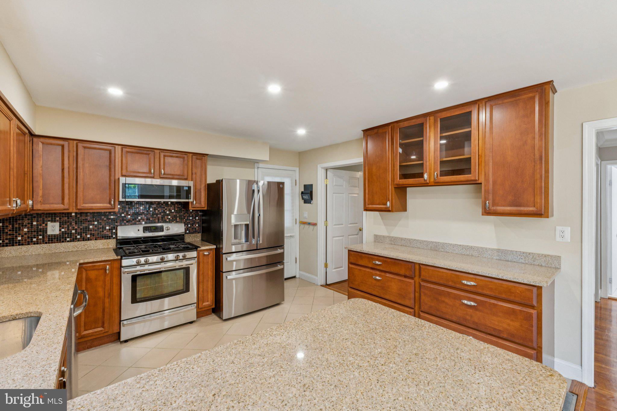 1900 Briggs Road Silver Spring, MD 20906 - Photo 12 of 44 a kitchen with stainless steel appliances granite countertop a stove and a refrigerator