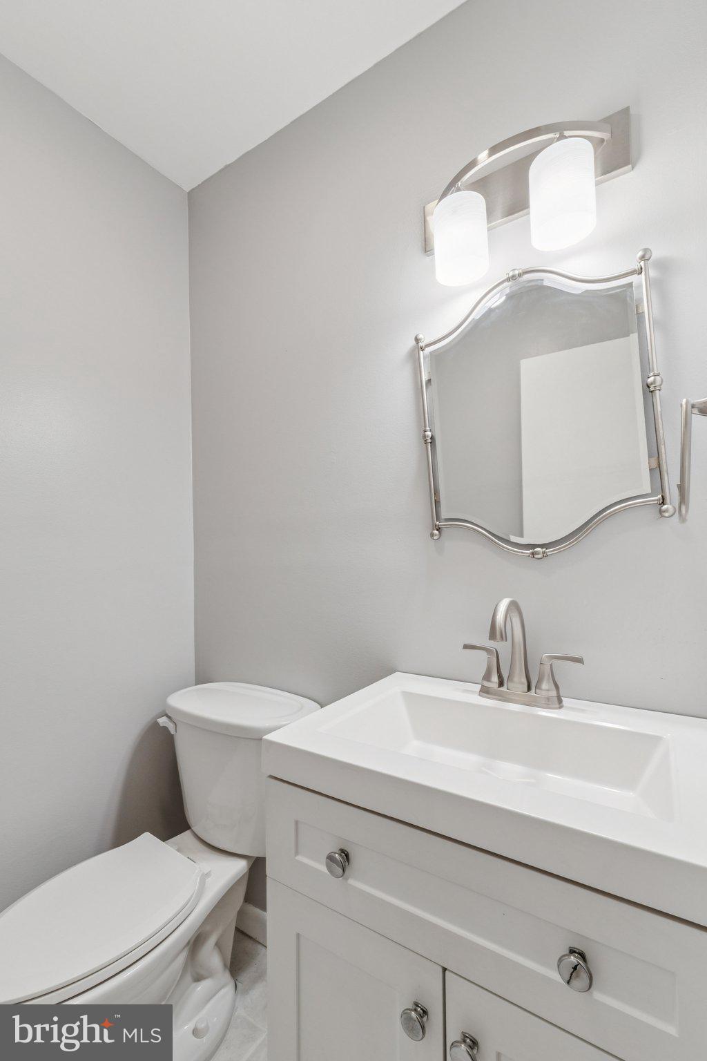 1900 Briggs Road Silver Spring, MD 20906 - Photo 18 of 44 a bathroom with a toilet sink and mirror