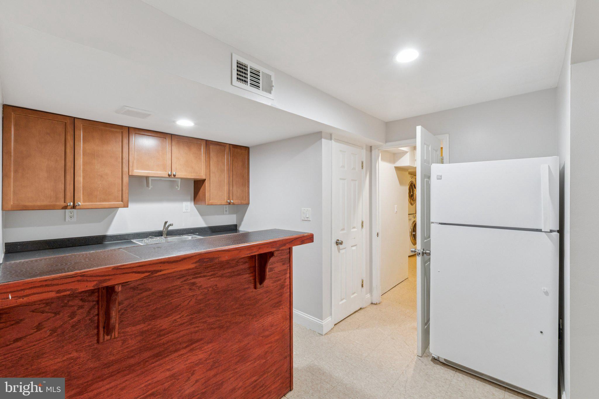 1900 Briggs Road Silver Spring, MD 20906 - Photo 31 of 44 a kitchen with a refrigerator a stove top oven a sink and cabinets