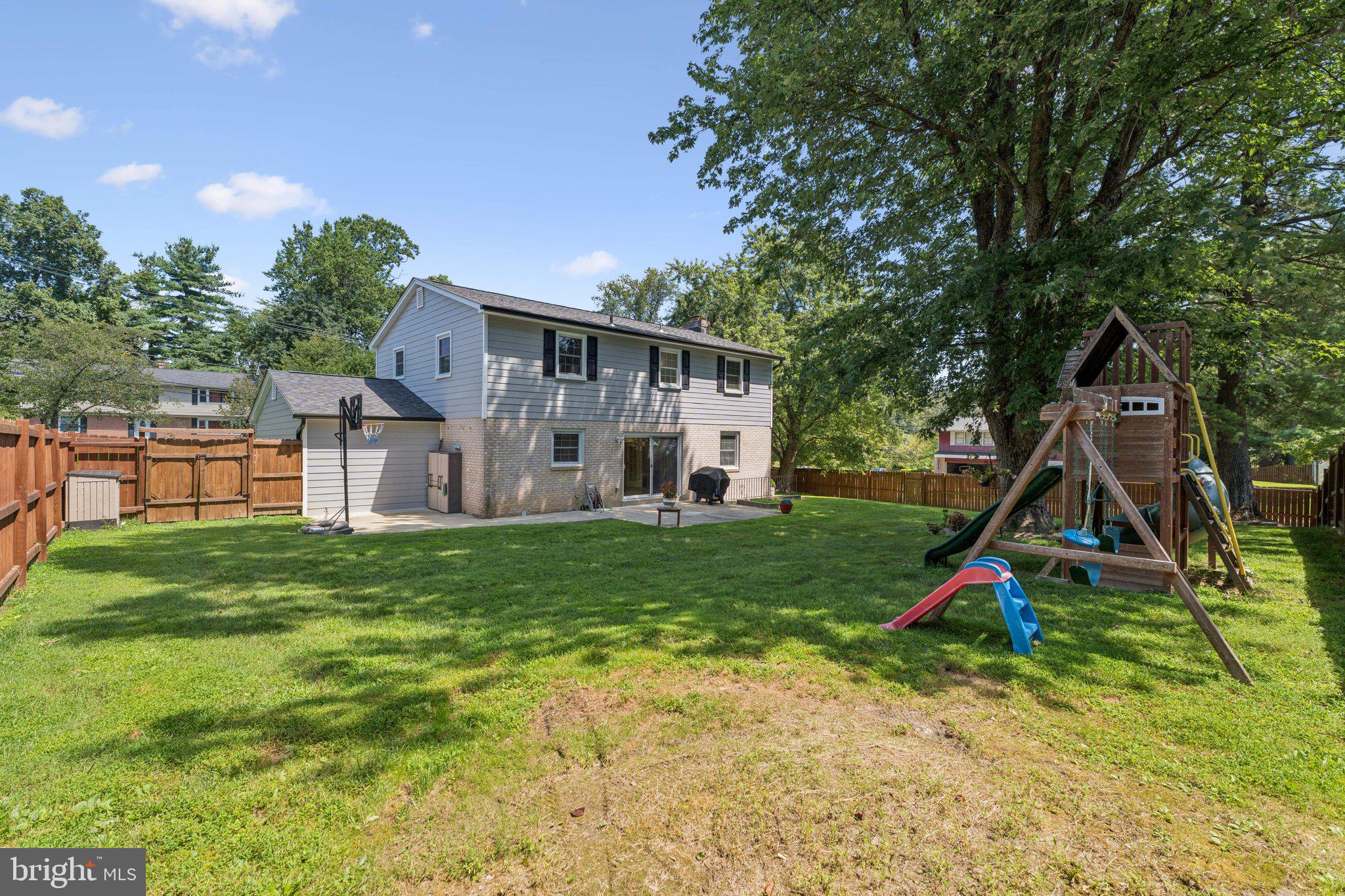1900 Briggs Road Silver Spring, MD 20906 - Photo 40 of 44 a view of a backyard with a slide trees and wooden fence