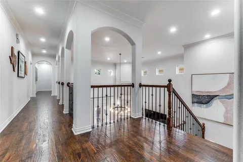 a view of a hallway with wooden floor and stairs