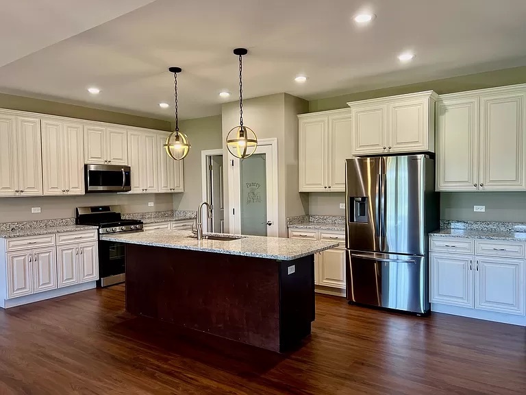 26501 Stephanie Drive Channahon, IL 60410 - Photo 11 of 14 a kitchen with stainless steel appliances granite countertop a refrigerator a sink dishwasher a stove and white cabinets with wooden floor