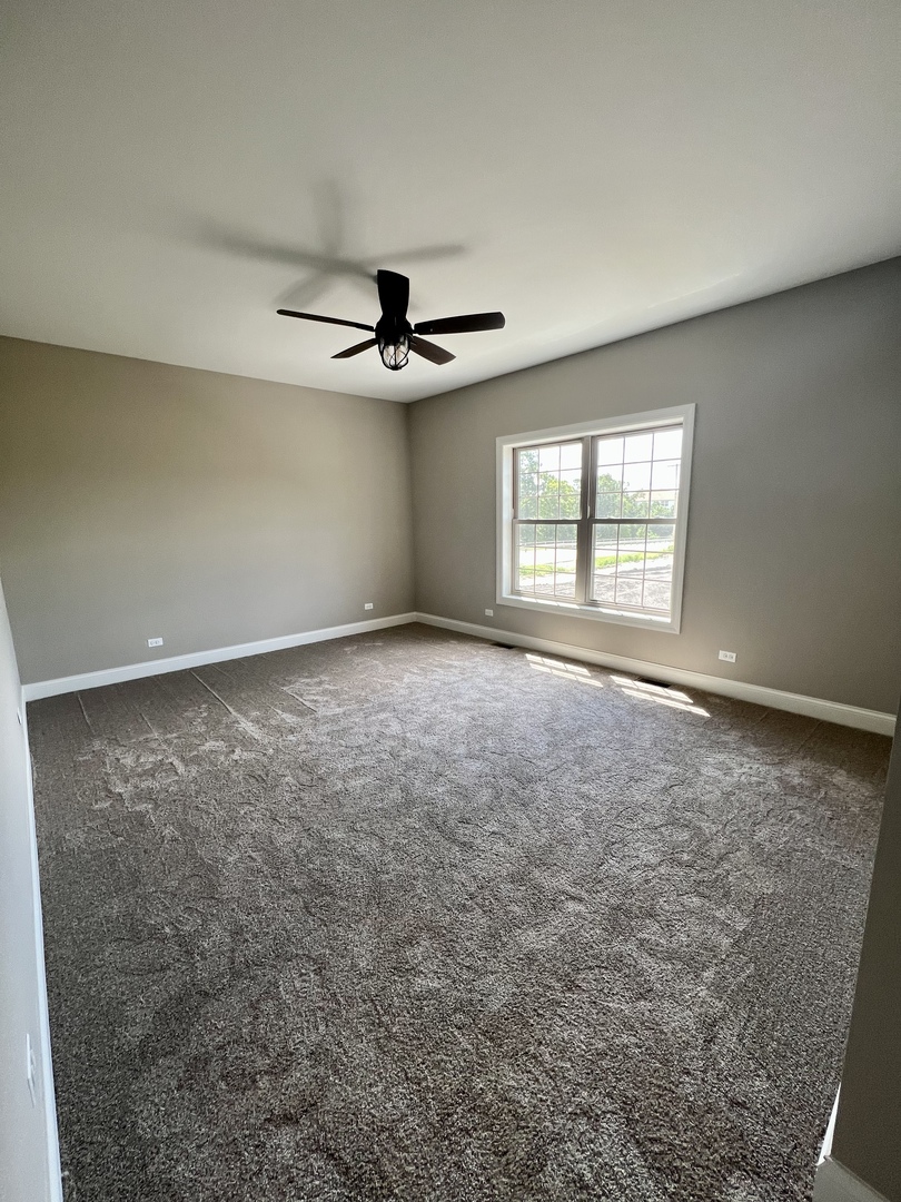 26501 Stephanie Drive Channahon, IL 60410 - Photo 6 of 14 an empty room with windows and ceiling fan