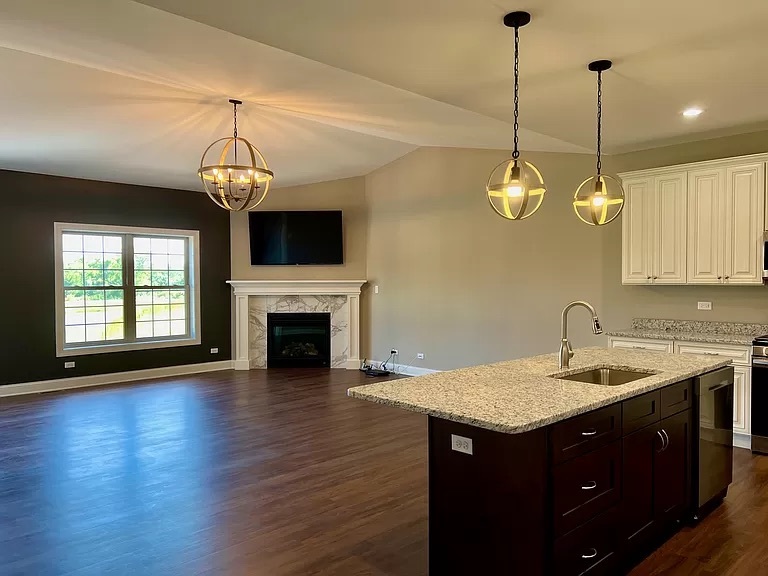 26501 Stephanie Drive Channahon, IL 60410 - Photo 9 of 14 a kitchen with a sink chandelier and a fireplace