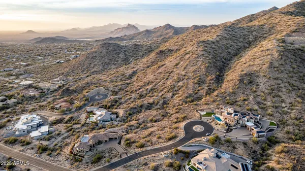 an aerial view of house with yard and mountain view in back