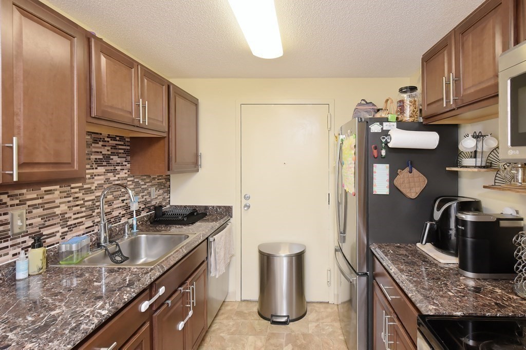 32 Silver Hill Lane, Unit 1 Natick, MA 01760 - Photo 15 of 36 a kitchen with granite countertop a sink stove and refrigerator