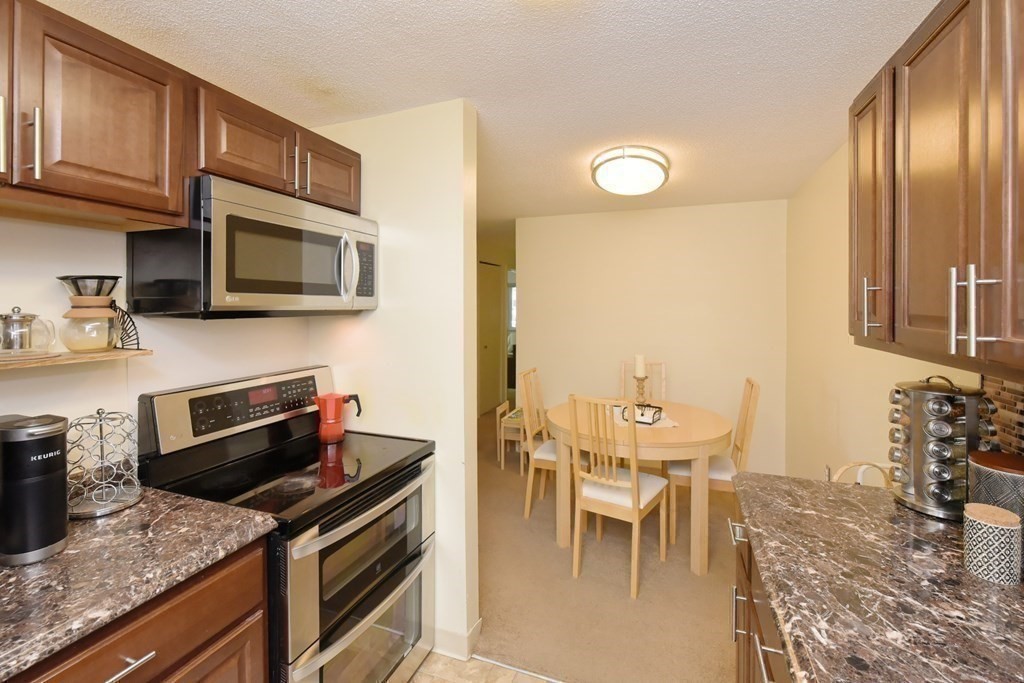 32 Silver Hill Lane, Unit 1 Natick, MA 01760 - Photo 17 of 36 a kitchen with stainless steel appliances granite countertop a stove a sink and a microwave