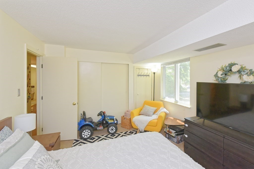 32 Silver Hill Lane, Unit 1 Natick, MA 01760 - Photo 23 of 36 a bedroom with furniture and a flat screen tv