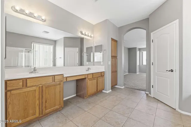 a large bathroom with a large mirror vanity and a sink