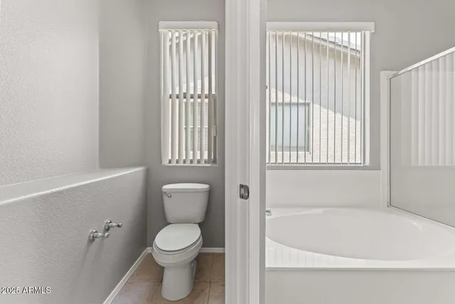 a white toilet sitting next to a bathtub