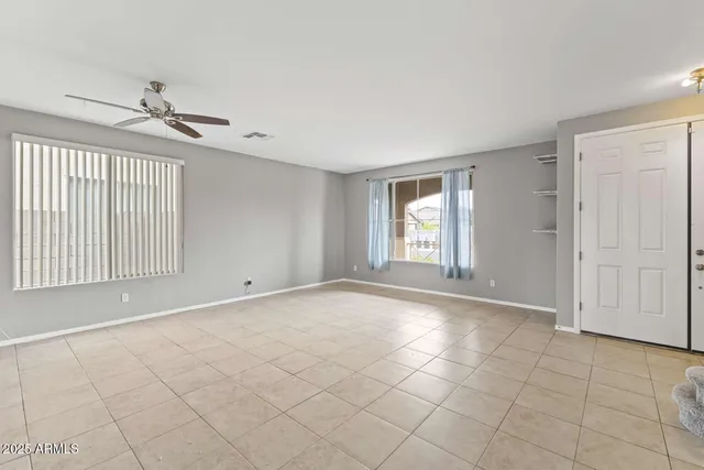 a view of an empty room with a chandelier fan