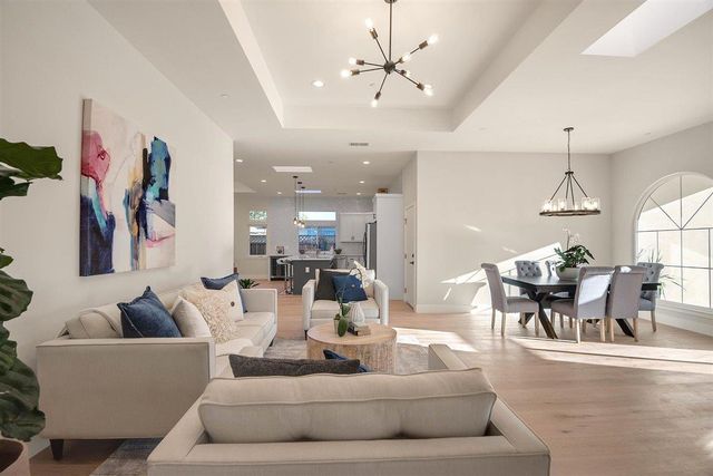 a living room with furniture and a chandelier