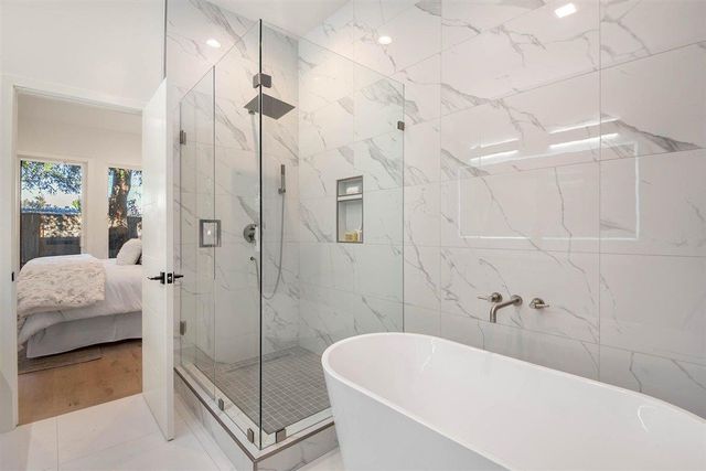 a bathroom with a tub a toilet and a shower