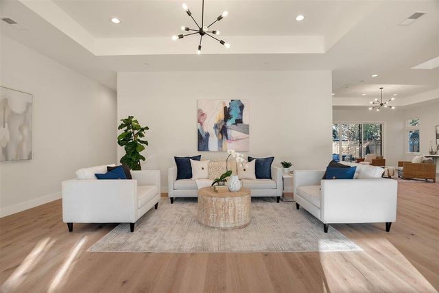 a living room with furniture and a chandelier