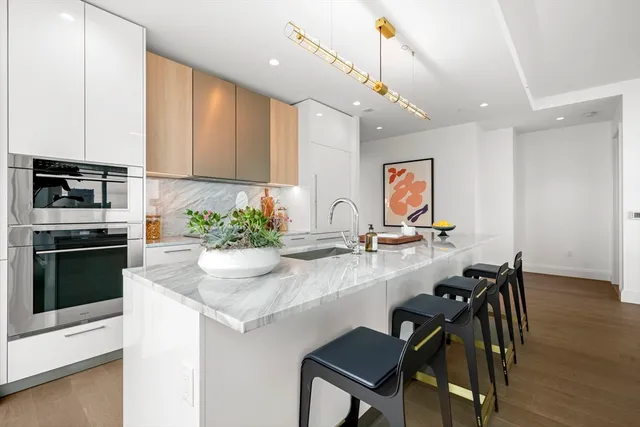 a kitchen with stainless steel appliances kitchen island granite countertop a stove a sink and a refrigerator