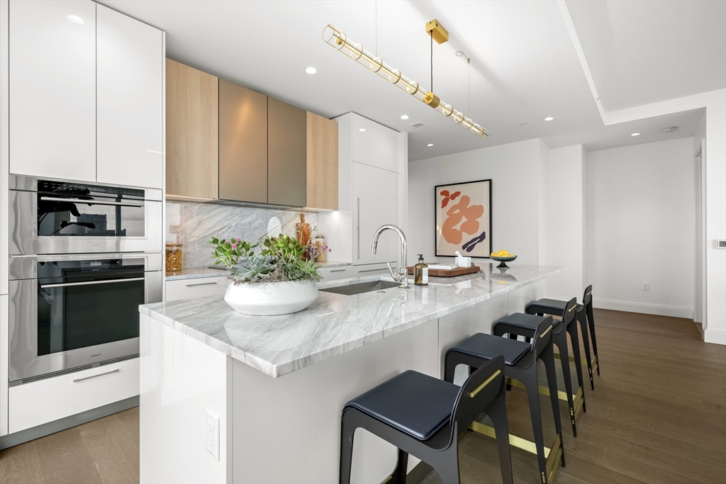 a kitchen with stainless steel appliances kitchen island granite countertop a stove a sink and a refrigerator