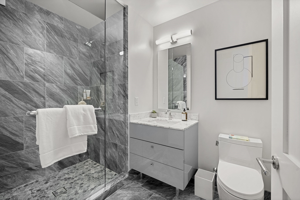 240 Devonshire Street, Unit 5612 Boston, MA 02110 - Photo 10 of 42 a bathroom with a toilet sink and mirror