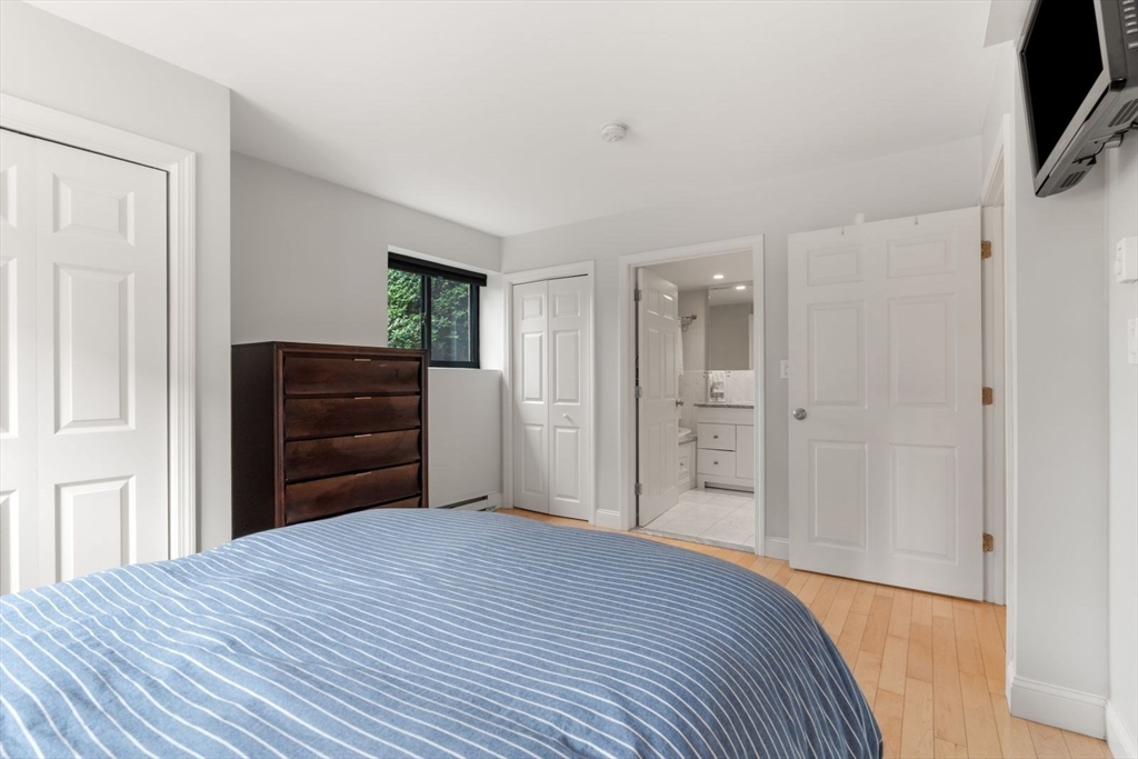 135 Franklin Street, Unit 101 Stoneham, MA 02180 - Photo 12 of 24 a bedroom with a bed and a flat screen tv