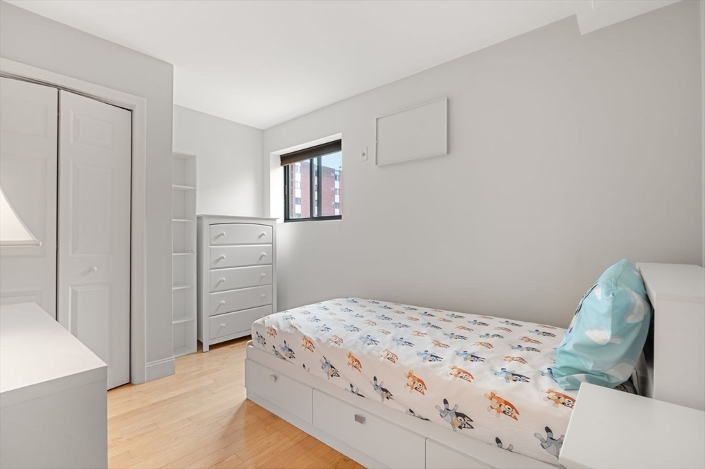 135 Franklin Street, Unit 101 Stoneham, MA 02180 - Photo 16 of 24 a bedroom with a bed and a dresser