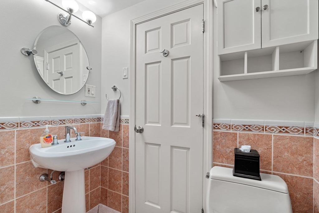 135 Franklin Street, Unit 101 Stoneham, MA 02180 - Photo 17 of 24 a bathroom with a sink a mirror and a toilet