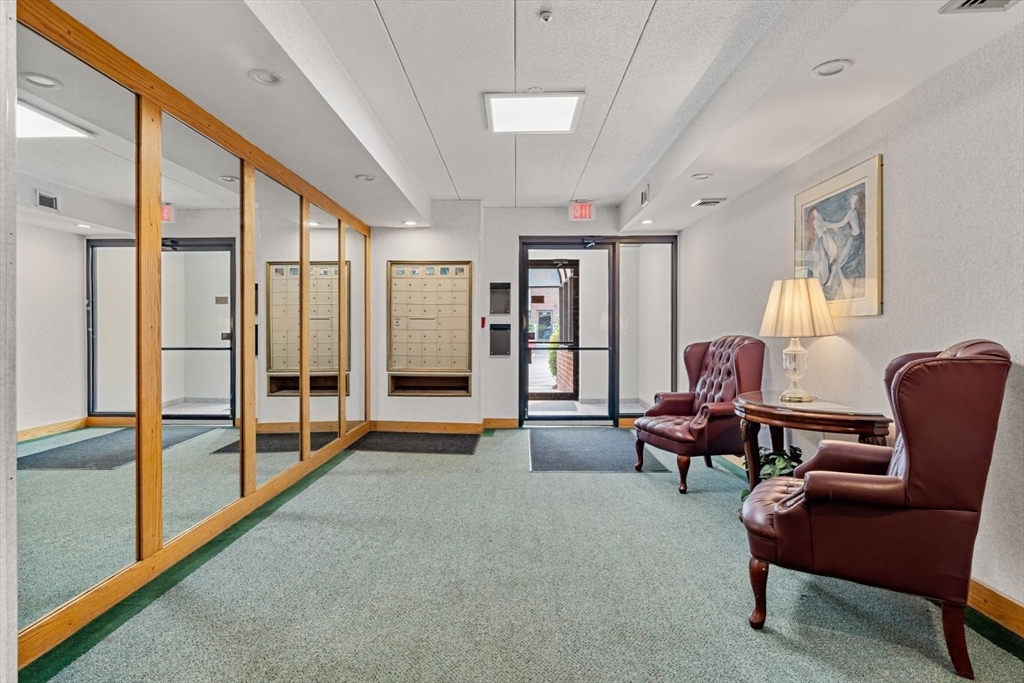 135 Franklin Street, Unit 101 Stoneham, MA 02180 - Photo 20 of 24 a living room with furniture and a floor to ceiling window
