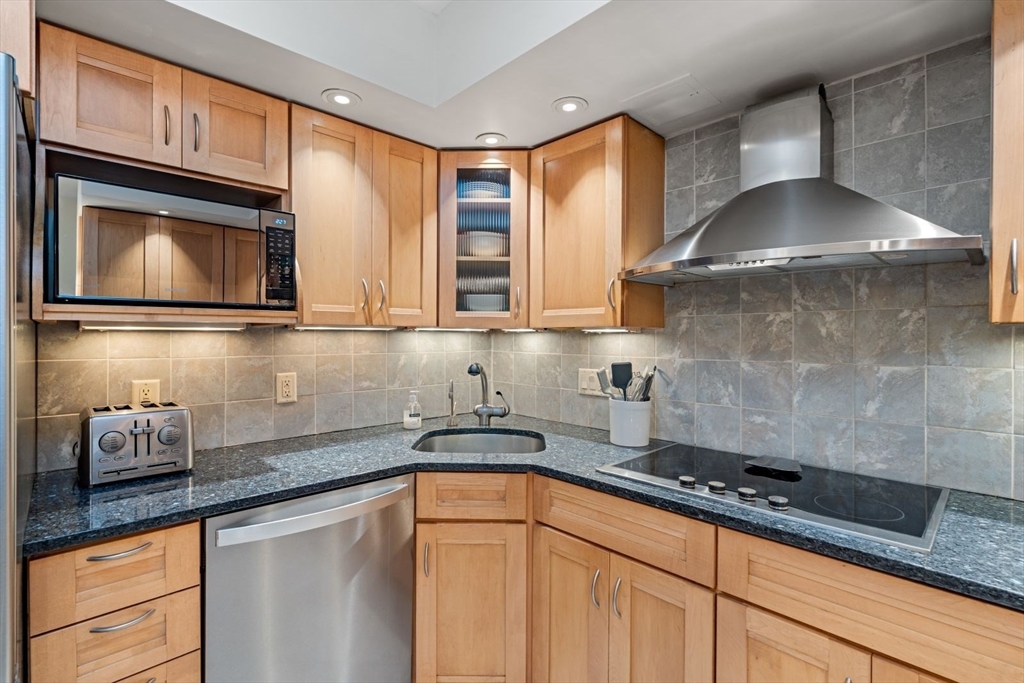 135 Franklin Street, Unit 101 Stoneham, MA 02180 - Photo 2 of 24 a kitchen with stainless steel appliances granite countertop a sink a stove and cabinets