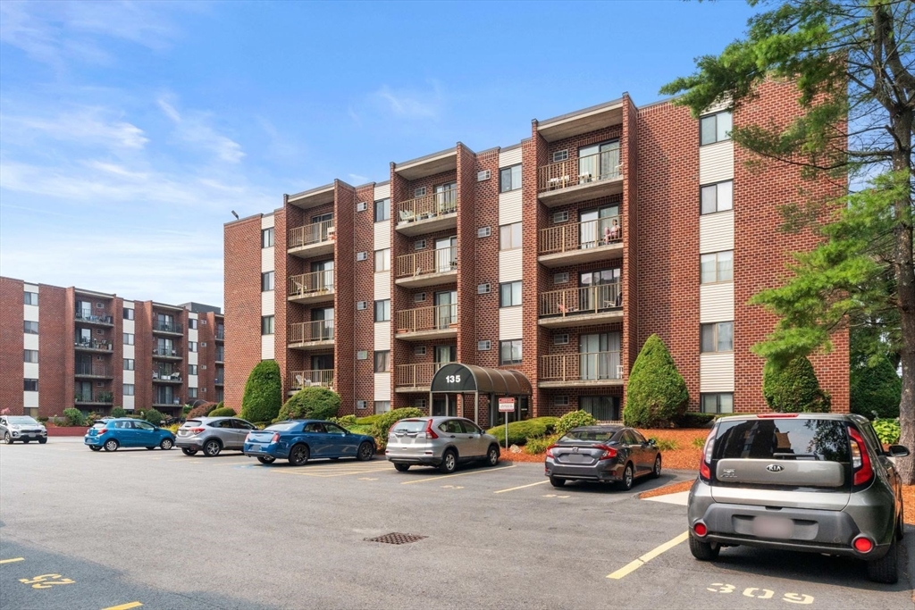 135 Franklin Street, Unit 101 Stoneham, MA 02180 - Photo 23 of 24 a car parked in front of a brick building