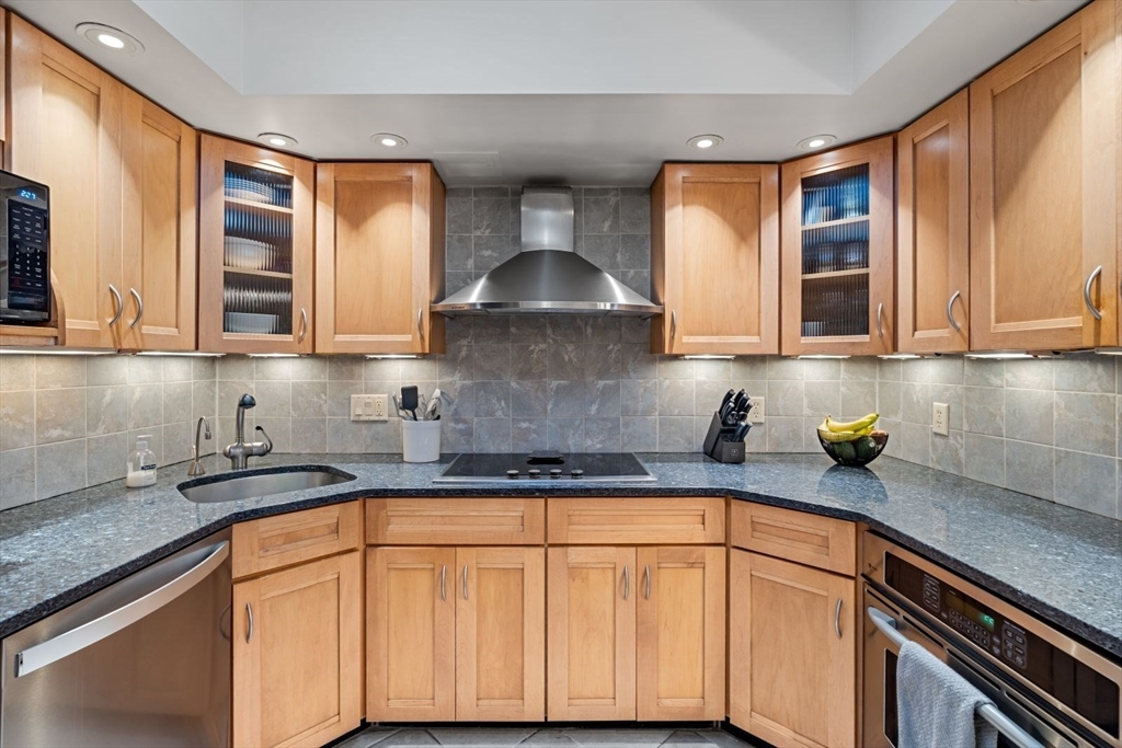 135 Franklin Street, Unit 101 Stoneham, MA 02180 - Photo 3 of 24 a kitchen with stainless steel appliances granite countertop a sink and a granite counter tops