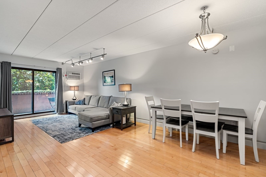 135 Franklin Street, Unit 101 Stoneham, MA 02180 - Photo 6 of 24 a living room with furniture a window and wooden floor