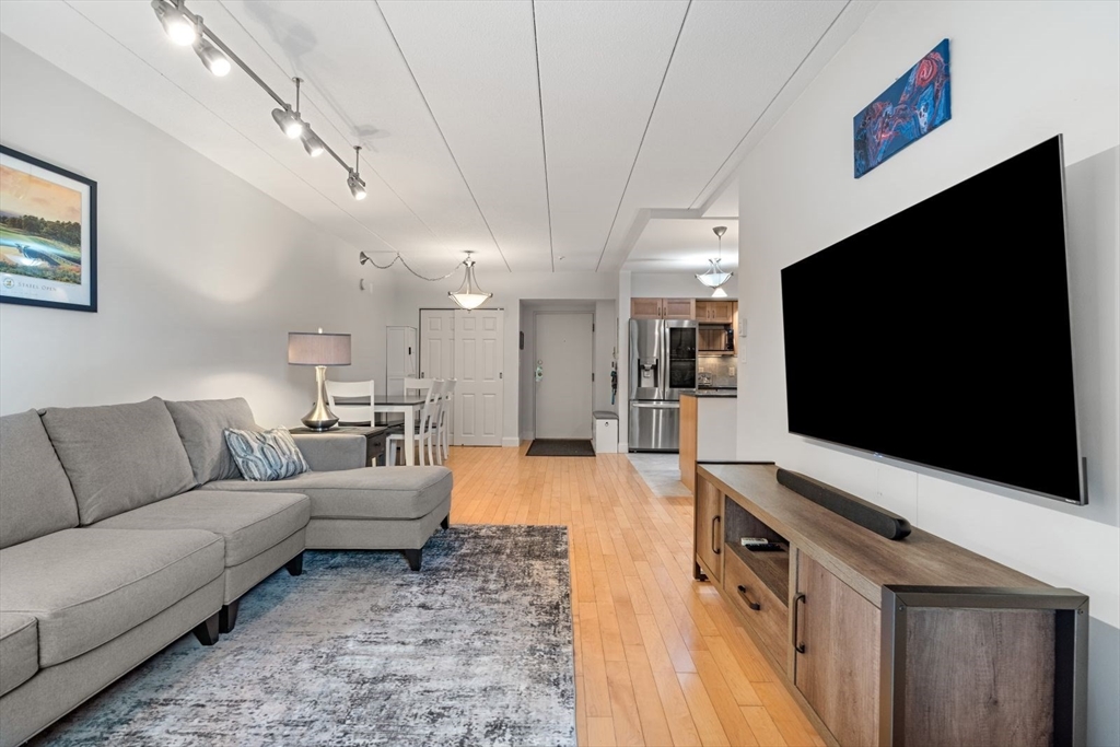 135 Franklin Street, Unit 101 Stoneham, MA 02180 - Photo 7 of 24 a living room with furniture and a flat screen tv
