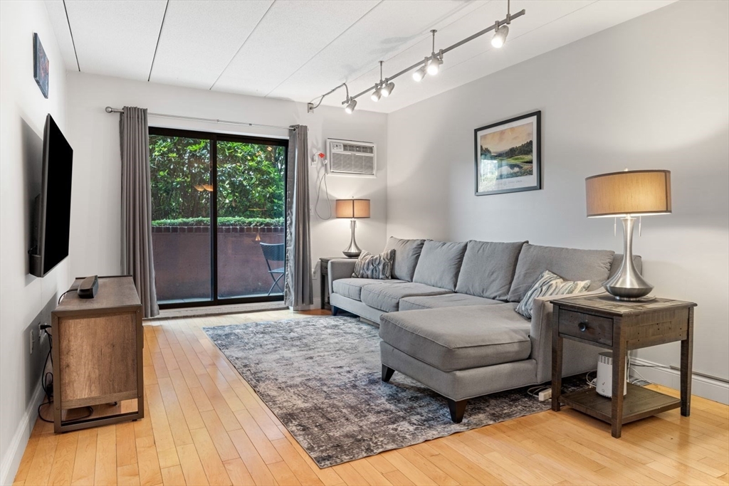 135 Franklin Street, Unit 101 Stoneham, MA 02180 - Photo 8 of 24 a living room with furniture and a flat screen tv