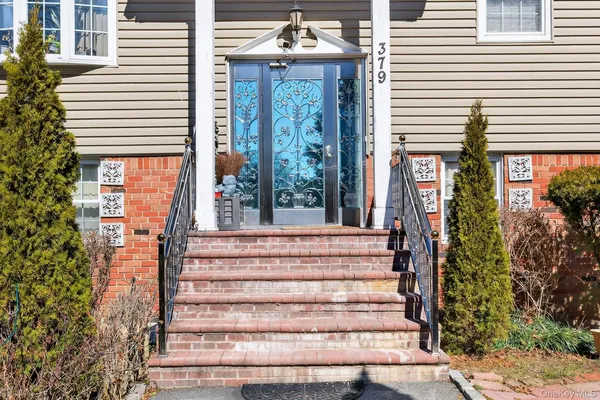 a front view of a house with plants and windows