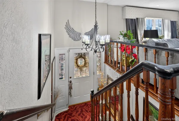 a view of an entryway wooden floor and chandelier