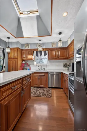 a kitchen with stainless steel appliances granite countertop a sink a stove and a wooden floors