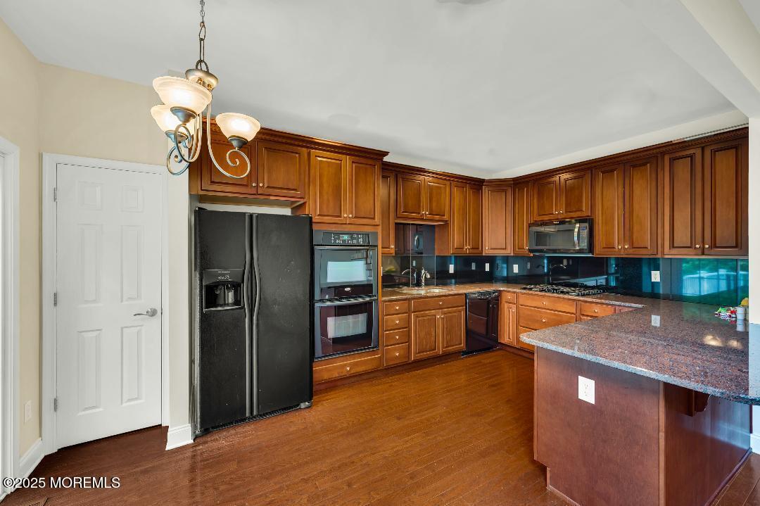 59 Brookfield Drive Jackson, NJ 08527 - Photo 13 of 42 a kitchen with stainless steel appliances granite countertop a refrigerator a sink dishwasher a stove and white countertops with wooden floor