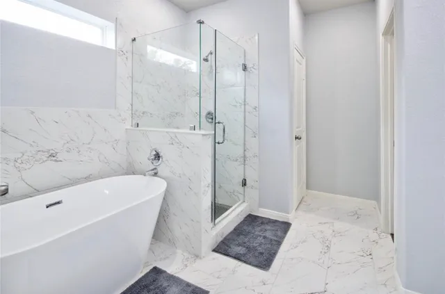 a bathroom with a tub a toilet and a shower