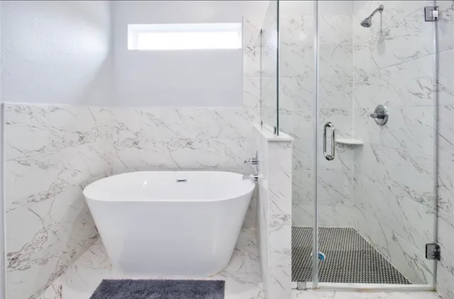 a white bath tub sitting in a bathroom and a shower