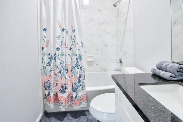a bathroom with a toilet and a shower curtain
