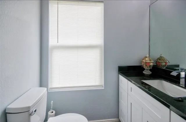 a bathroom with a sink a toilet and a window