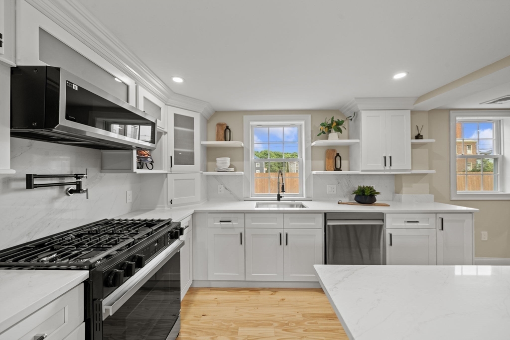 162 High Street, Unit B Danvers, MA 01923 - Photo 5 of 32 a kitchen with stainless steel appliances a sink a stove and cabinets