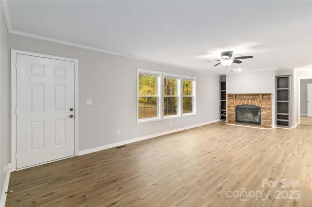 a view of an empty room with a fireplace and a window