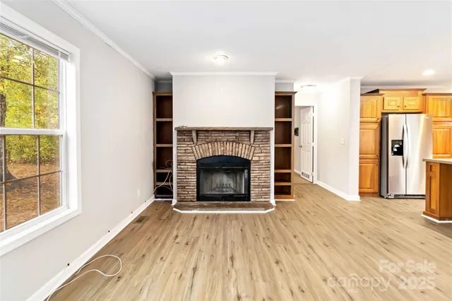 a view of a livingroom with a fireplace and window