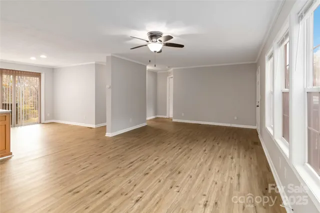 a view of a livingroom with wooden floor and a ceiling fan